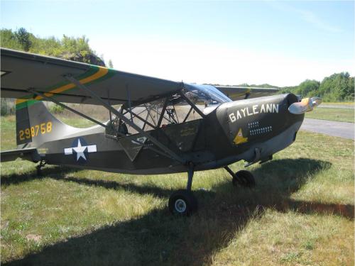 Side view of gray-colored monoplane with name "Gayle Ann" written on the side of the nose. A star is painted behind the cockpit and registration number 298758 is painted in yellow on the vertical stabilizer.