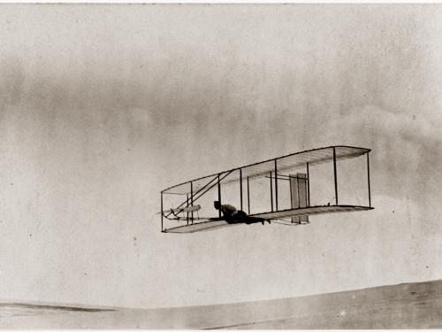 Man soars a few feet above the ground in a glider