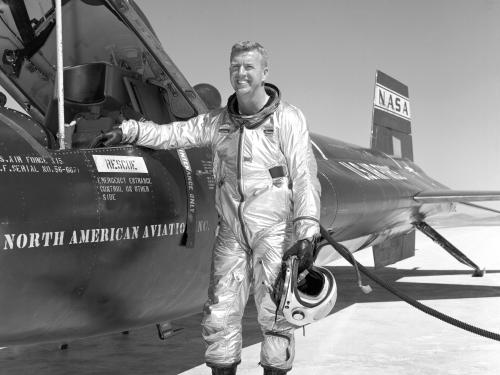 Joe Walker, a white man, stands next to a record-breaking experimental rocket plane that he flew.