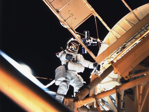 A white male astronaut performs a spacewalk outside of the Skylab Space Station.