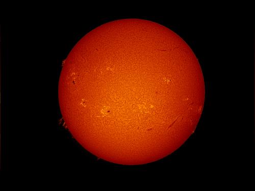 Disk view of the Sun's atmosphere. Floating gases off the edge of the disk called prominences are visible as well as filaments (dark lines) on the disk of the Sun. Sunspots (dark spots) and phages (lighter-colored clouds) are also visible on the disk.