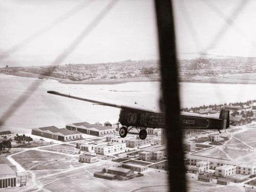 The T-2, a monoplane which attempted the first transcontinental flight, flies over a town prior to landing near San Diego, California.