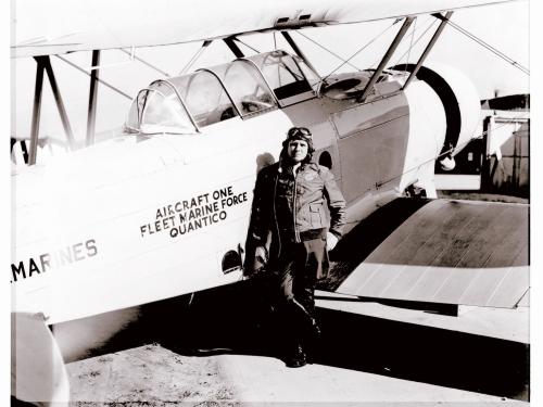 Roy Geiger, a white male pilot, stands next to an aircraft wearing aviator gear.