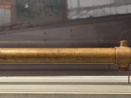 A bronze-colored tube-shaped pump used to remove water from pontoons.