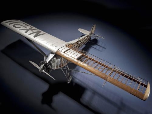 Top view of cutaway model of the Spirit of St. Louis, a silver-colored monoplane with one engine.