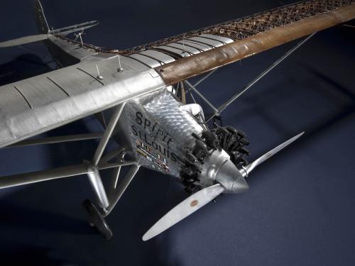 Top view of a cutaway model of the Spirit of St. Louis, a silver-colored monoplane with one engine. This view focuses on the nose and engine of the plane.