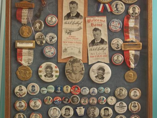 A collection of pins and ribbons celebrating Charles Lindbergh's flights.