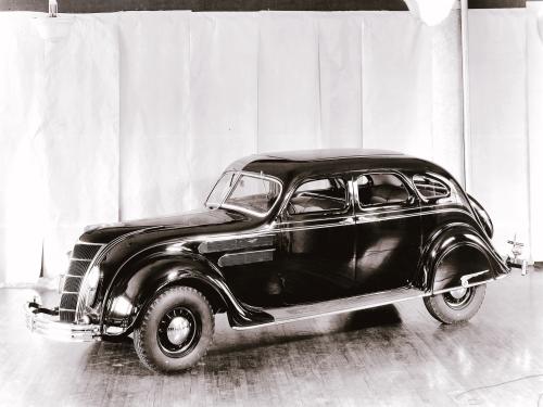 Side view of dark-colored antique car with four seats.