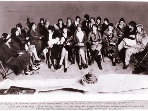 A large group of women pilots sit together.