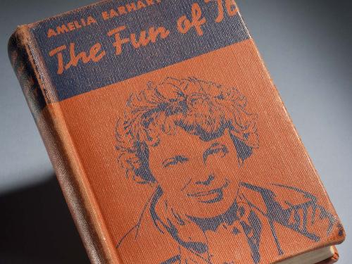 Orange and black book cover featuring a drawing of Amelia Earhart. The book is titled "The Fun of It" and is written by Amelia Earhart.