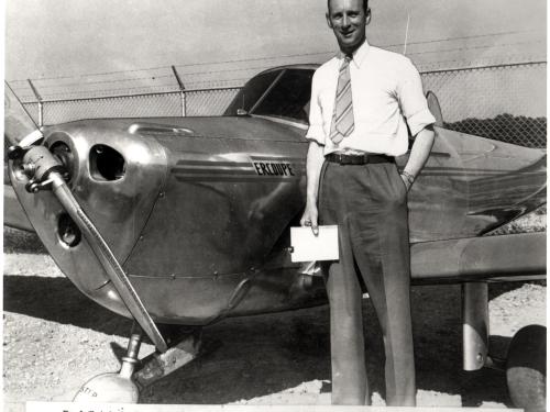 Fred Weick, a white man, stands next to his metal aircraft.