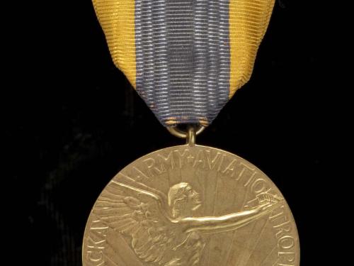 Front of aviation medal. Medallion features an etching of a person with wings in flight as well as the name of the trophy. Suspended using yellow and black fabric.