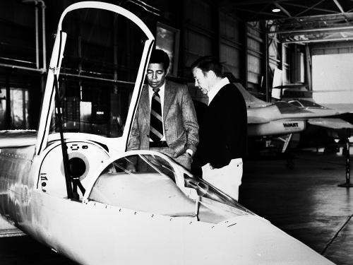 Isaac Gilliam IV, an African-American male, stands next to another man near a white aircraft.