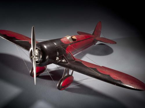 Red and brown-colored monoplane model with one engine.