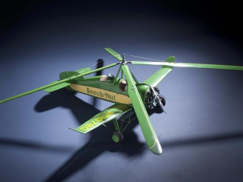 Top view of green and yellow monoplane model with one engine and rotating four-blade propellor above the cockpit. Registration number "NC10780" is painted on the right wing and the name "Beech-Nut" is painted in green.