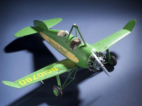 Top view of green and yellow monoplane model with one engine. Registration number "NC10780" is painted on the right wing and the name "Beech-Nut" is painted in green.