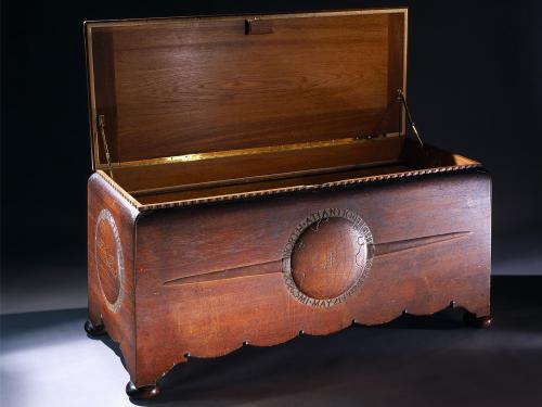 Opened wooden chest commissioned to hold the trophies, plaques, and memorabilia belonging to Amelia Earhart. The chest features motifs highlighting three of Earhart's milestone flights.