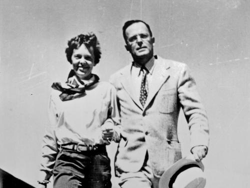 Amelia Earhart and George Palmer Putnam, a white woman and man respectively, pose informally.