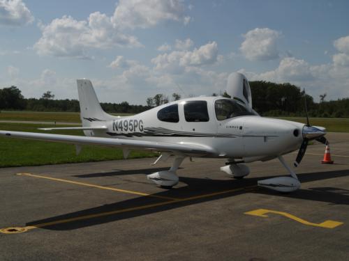 Side view of white monoplane with one engine and fixed landing gear. Registration number "N495PG" painted near the rear of the fuselage in black paint.