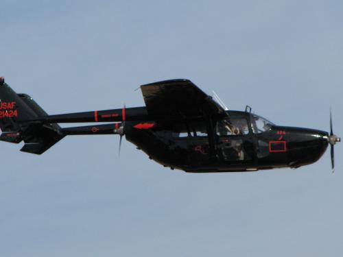 Side view of black, twin engine monoplane with engines placed on the back of the wings. Monoplane is in flight.