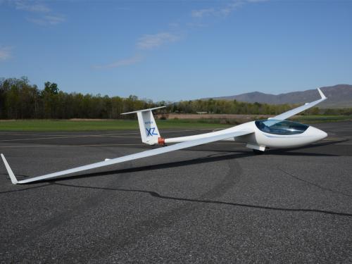 Side view of white glider monoplane with abnormally long wings.