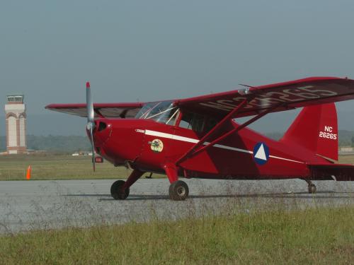 Side view of red monoplane with one engine.