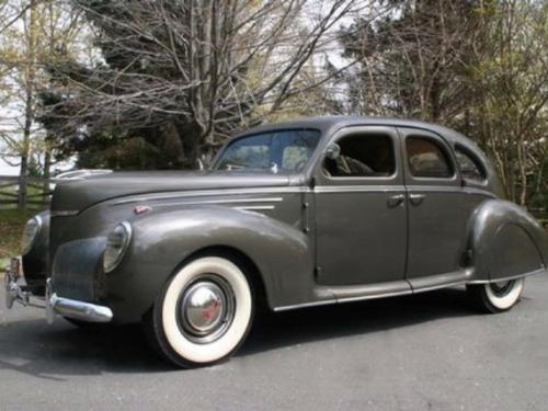 Side view of a 1930s, gray, four-door automobile.