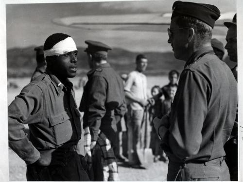 Lt. Andrew D. Mitchell, an African-American male pilot on the left, speaks to another officer following an escape attempt from German territory.