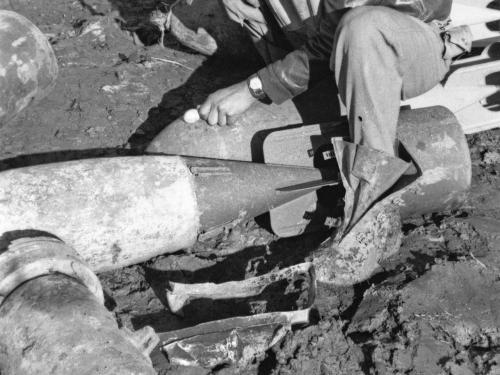 Lt. Elwood T. Driver, an African-American male pilot, sits and poses informally on top of rocket debris.