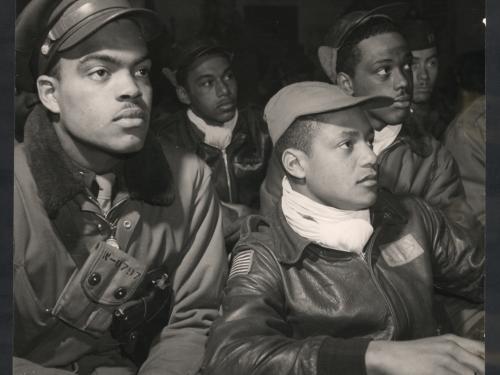 African-American male pilots listen to a mission briefing together.