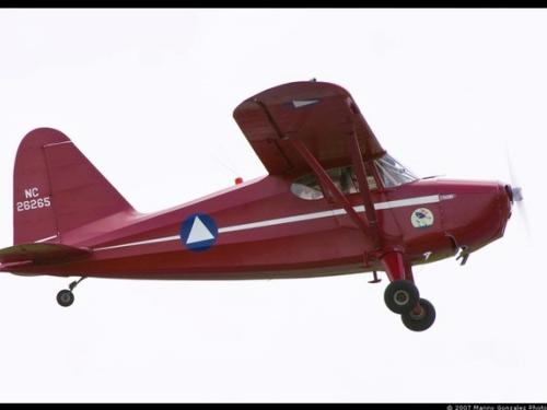 Side view of red monoplane with one engine. Registration number "N26265" is painted in white on the rudder.