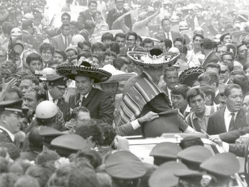 The three Apollo 11 astronauts (Neil Armstrong, Edwin "Buzz" Aldrin, Jr., and Michael Collins) are wearing sombreros and ponchos. They are surrounded by thousands of people in Mexico City, Mexico.