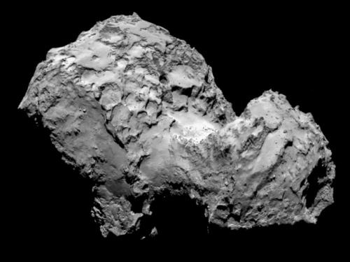 View of a large, oblong-shaped comet body with multiple significant craters visible.