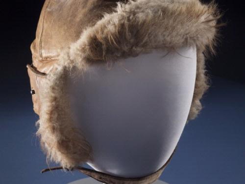 Brown aviation helmet with leather outer lining and fur-lined interior. Styled on mannequin.