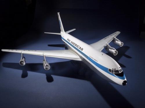 Plastic, white and blue commercial aircraft model with four engines attached to the sides of the plane. Aircraft has white and light blue Pan American World Airways livery.