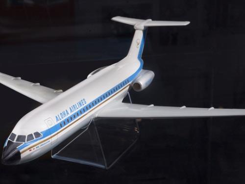 White, plastic commercial aircraft display model with a blue stripe. Aloha Airlines is written near the front of the fuselage on the side of the plane.