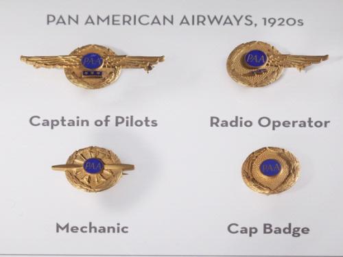 A set of four badges used by Pan American Airways during the 1920s. Each badge features a dark blue circle surrounded by a golden circle.