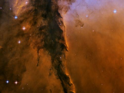 A nebula of dust and gases with orange and light purple colours.