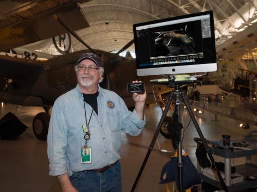 A Museum staff member uses a display monitor to provide photography advice at an open house event for the Museum.