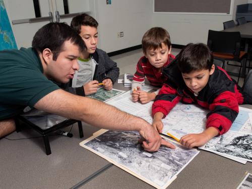 A family of four people look at maps as part of a game at the Udvar-Hazy Center.