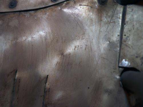 Signatures from engineers and guards etched onto a portion of a silver monoplane. 