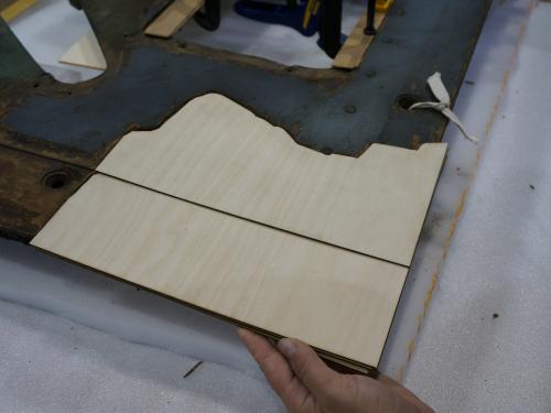 A Museum staff member places a fifth layer of plywood intended for use in repairing holes in a World War II era aircraft.