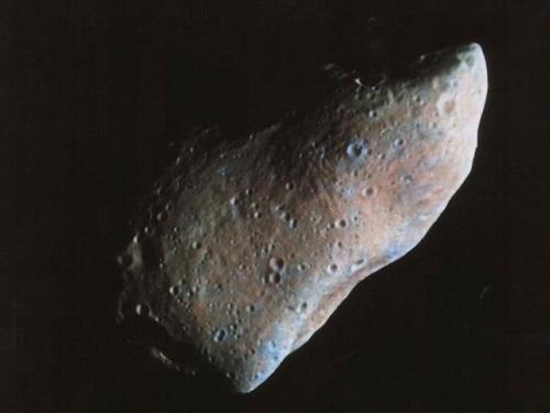 Photo showing a partial view of an oblong-shaped asteroid