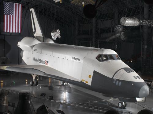 Side view of white and black space shuttle on display at the museum.