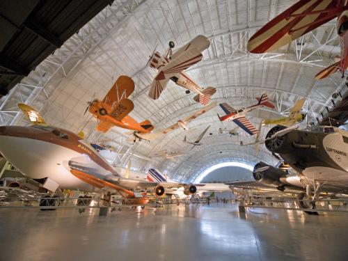 A hangar at the Steven F. Udvar-Hazy Center featuring several aircraft displayed from the ceiling or from the floor.