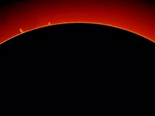 View of multiple large prominences of plasma floating away from the Sun.