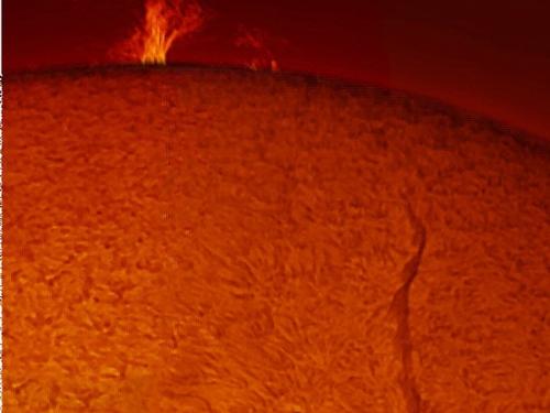 View of the Sun focused on a large prominence of plasma floating away from the Sun and a snake-shaped filament on the disc.