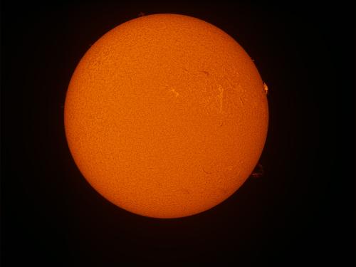 Disk view of the Sun with a prominence of plasma on the right side of the disk.