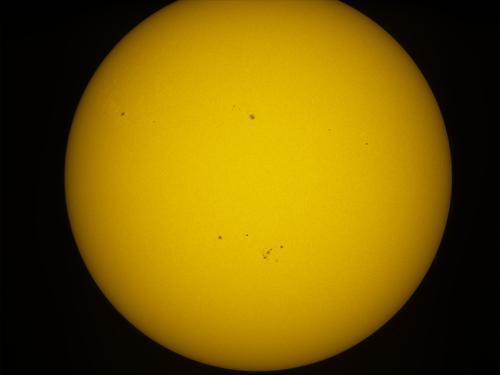 Disk view of the Sun with a solar flare visible in the bottom right quadrant of the Sun's visible surface.