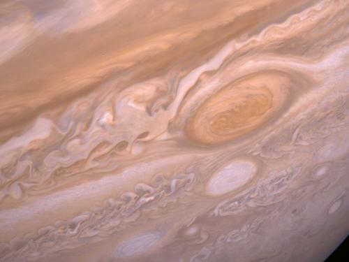 A portion of the gaseous surface of Jupiter with its Great Red Spot on the right side. 